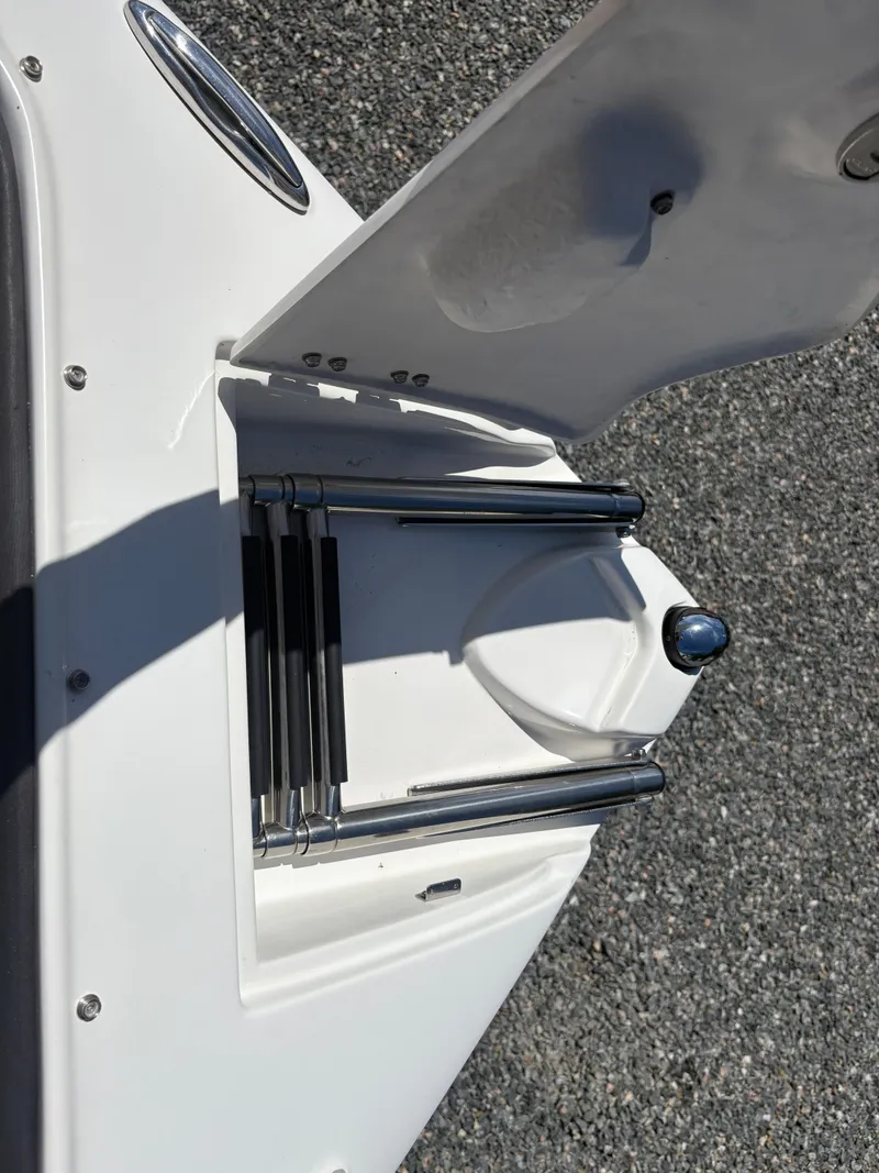 Slide: The Image of 2018 Rinker 26QX BR boat ladder compartment, open on a sunny day. - 31