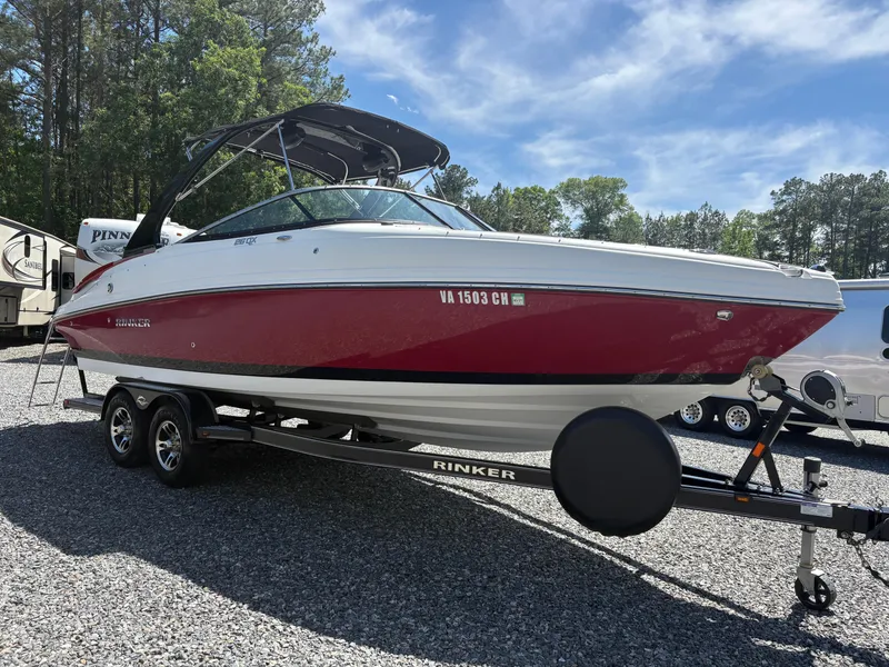 Slide: The Image of 2018 Rinker 26QX BR boat on trailer, red and white, parked outdoors. - 5