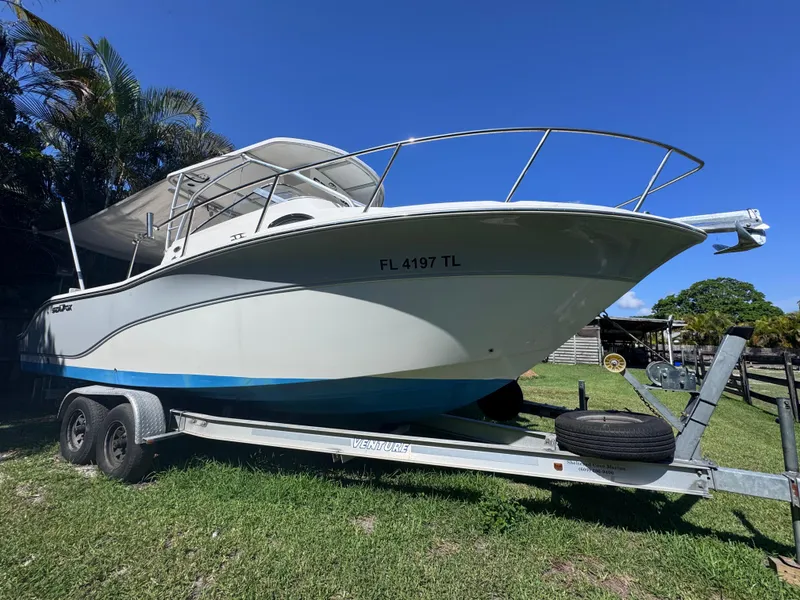 Slide: The Image of 2011 Sea Fox 256 WA Voyager boat on trailer, parked on grass. - 1