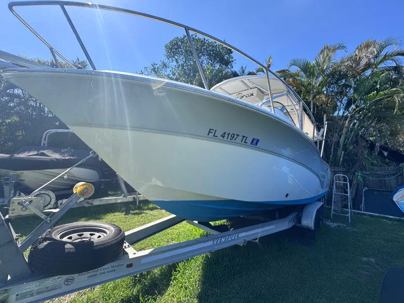 Slide: The Image of 2011 Sea Fox 256 WA Voyager boat on trailer, parked outdoors under clear blue sky. - 15