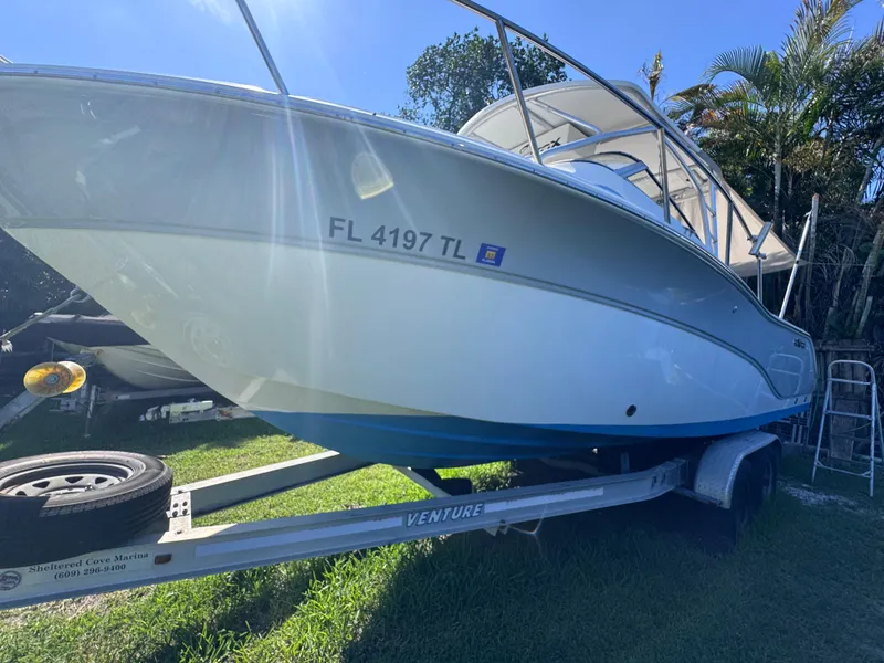 Slide: The Image of 2011 Sea Fox 256 WA Voyager boat on trailer, parked on grass under sunlight. - 16