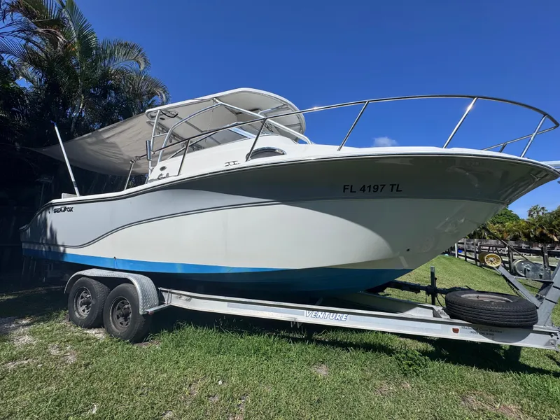 Slide: The Image of 2011 Sea Fox 256 WA Voyager boat on trailer, parked on grass under clear blue sky. - 3