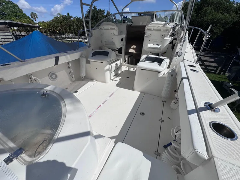 Slide: The Image of 2011 Sea Fox 256 WA Voyager boat interior with seating and helm, under clear blue sky. - 34