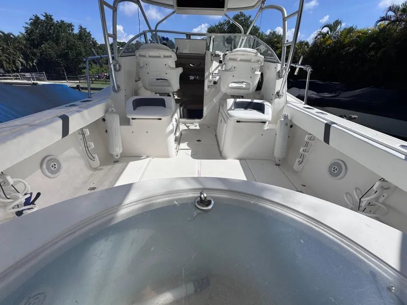 Slide: The Image of 2011 Sea Fox 256 WA Voyager boat interior with seating and helm, under clear blue sky. - 36