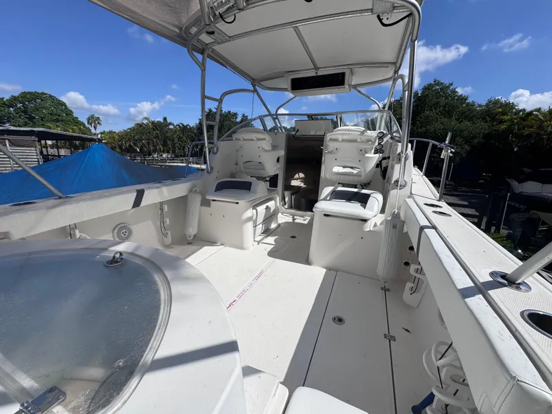 Slide: The Image of 2011 Sea Fox 256 WA Voyager boat interior with seating and helm, under a clear blue sky. - 37