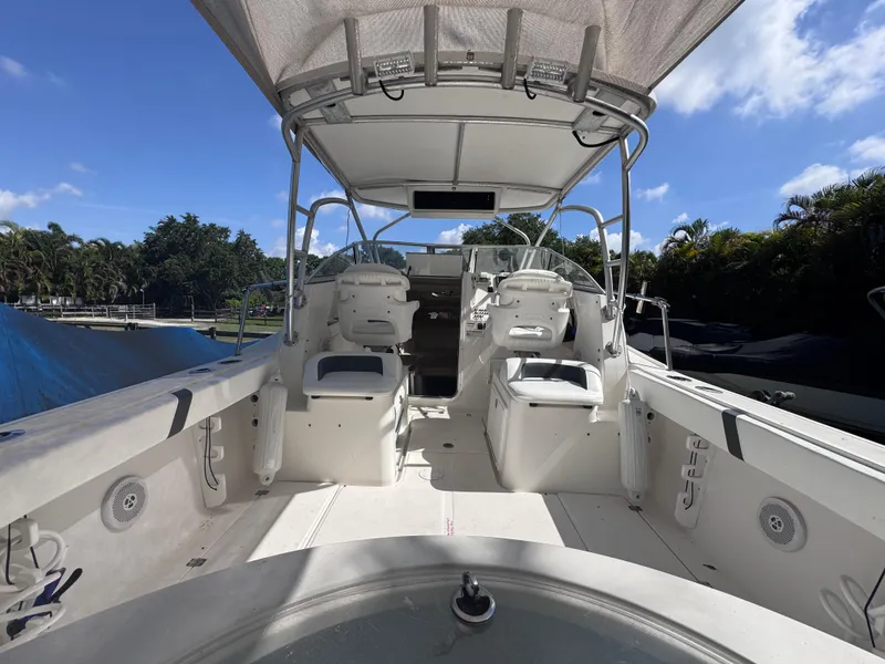 Slide: The Image of 2011 Sea Fox 256 WA Voyager boat interior with dual seating and canopy under clear sky. - 38