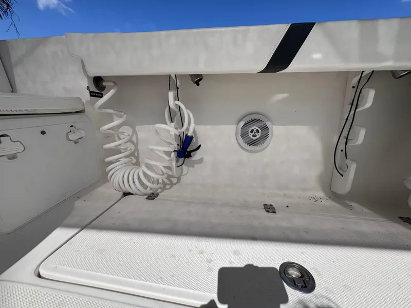 Slide: The Image of 2011 Sea Fox 256 WA Voyager boat storage compartment with coiled hose and speaker. - 43