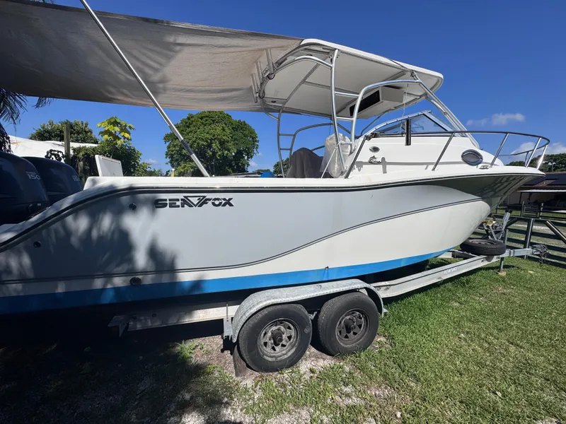 Slide: The Image of 2011 Sea Fox 256 WA Voyager boat on trailer, parked on grass under blue sky. - 6