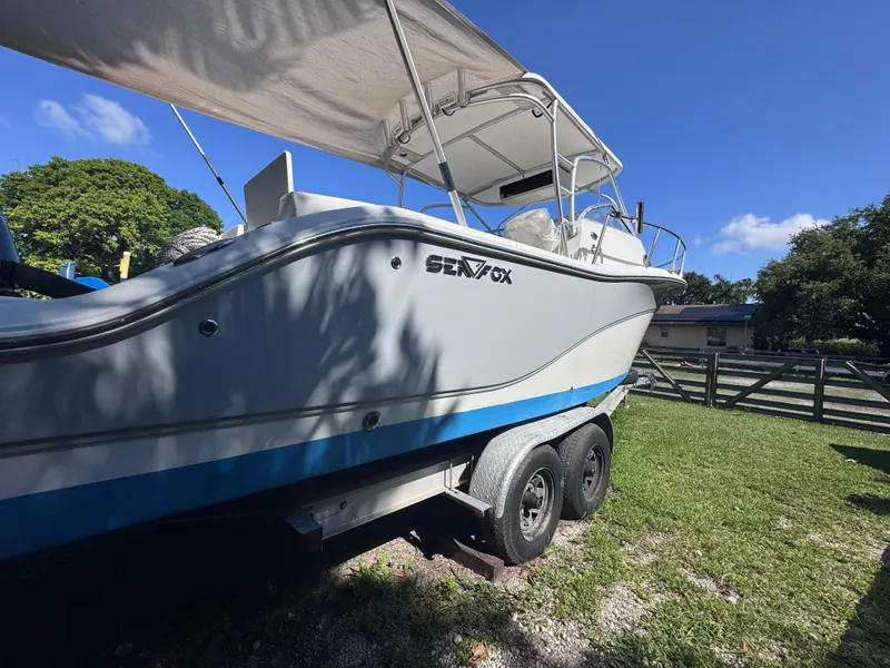Slide: The Image of 2011 Sea Fox 256 WA Voyager boat on trailer, parked on grass under blue sky. - 8