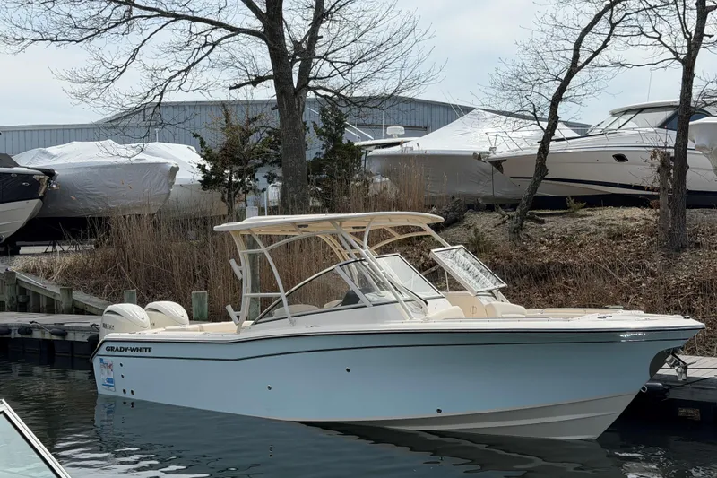 The Image of 2026 Grady-White Freedom 275 boat docked near trees and covered vessels. - 0