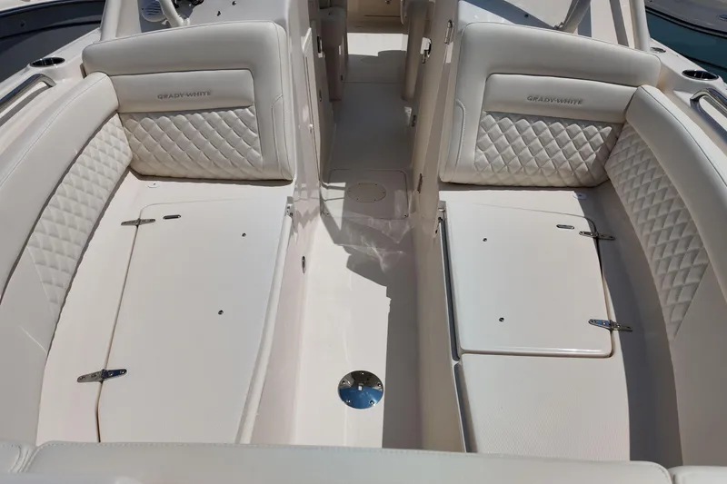 Slide: The Image of 2026 Grady-White Freedom 275 boat interior with luxurious white seating and storage compartments. - 22