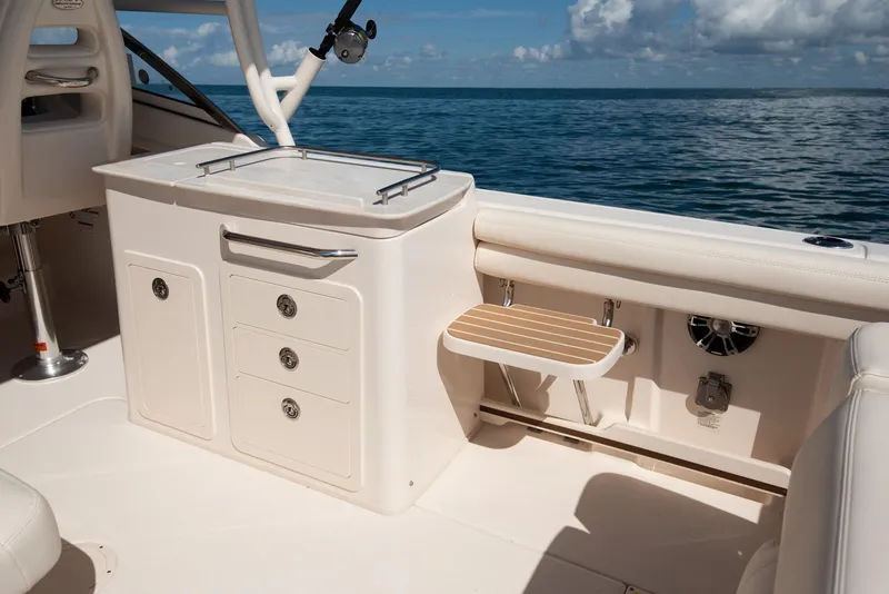 Slide: The Image of 2026 Grady-White Freedom 275 boat interior with seating and storage, displayed outdoors. - 5
