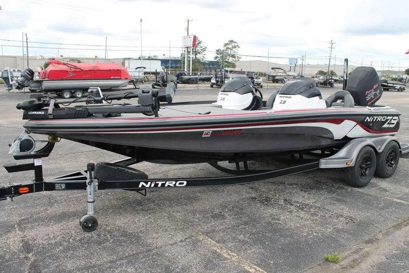 Slide: The Image of 2012 Nitro Z-9 boat on trailer, parked in a lot, featuring sleek design and dual consoles. - 3
