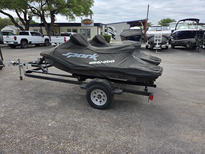 Slide: The Image of 2021 Sea-Doo Spark 2up on trailer, covered, in parking lot. - 3
