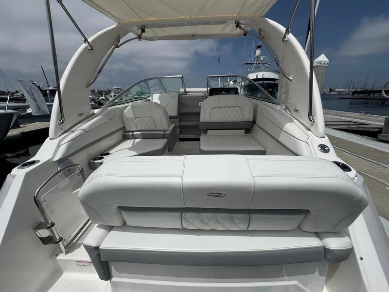 Slide: The Image of 2025 Regal 26 XO boat interior with white seating, docked at a marina. - 10