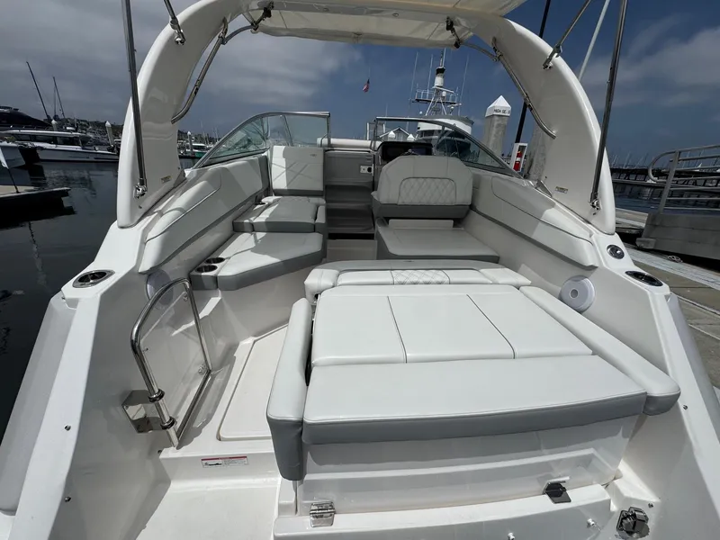 Slide: The Image of 2025 Regal 26 XO boat interior with spacious seating, docked at a marina. - 13