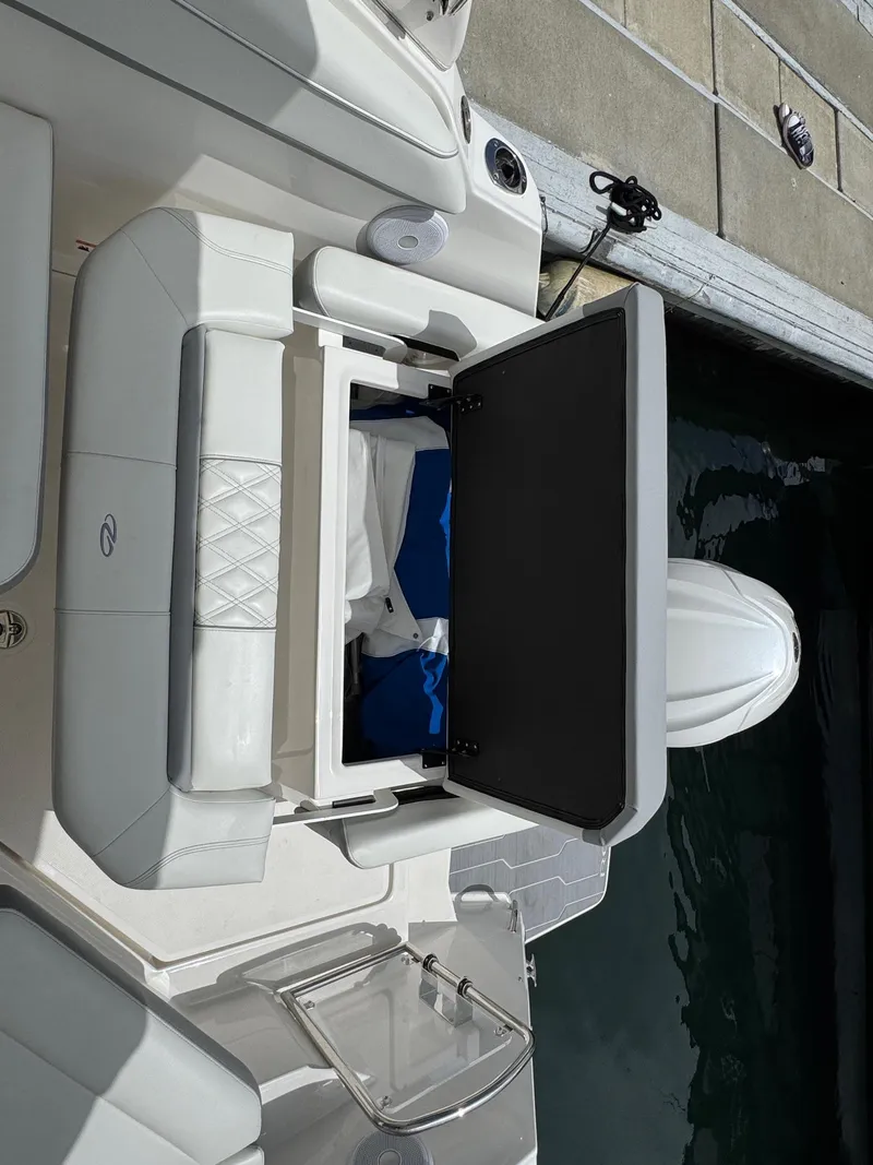 Slide: The Image of 2025 Regal 26 XO boat with open storage compartment, docked by the water. - 14