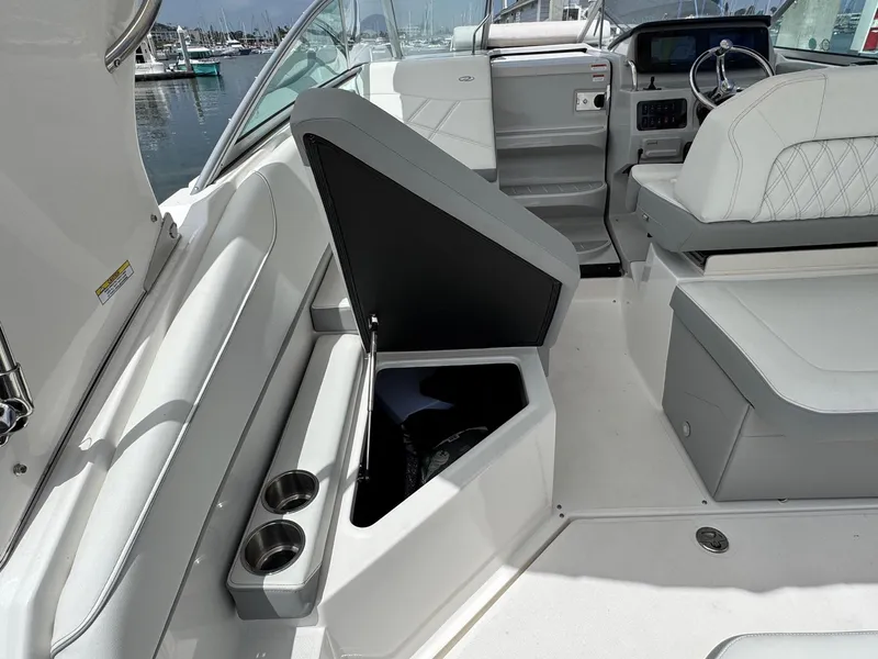 Slide: The Image of 2025 Regal 26 XO boat interior with open storage compartment and cup holders. - 19