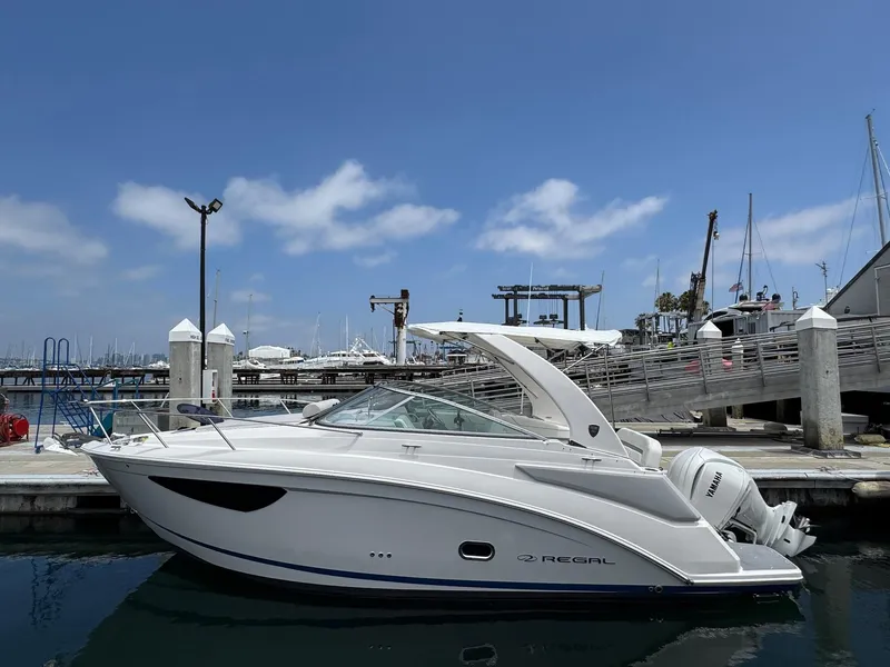 Slide: The Image of 2025 Regal 26 XO boat docked at marina under clear blue sky. - 2