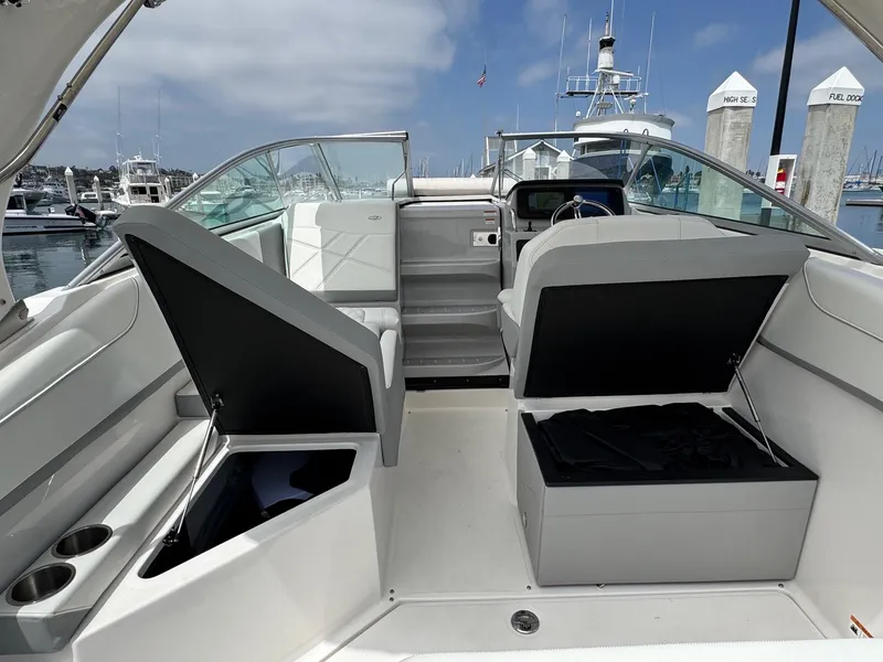Slide: The Image of 2025 Regal 26 XO boat interior with open storage compartments at a marina. - 20
