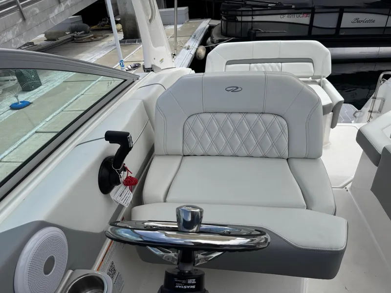 Slide: The Image of 2025 Regal 26 XO boat interior with white leather seating and steering wheel. - 25