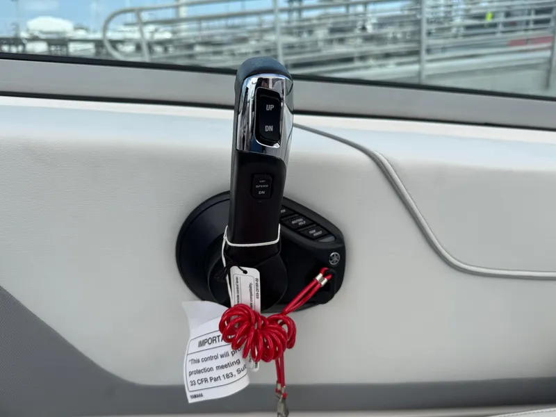 Slide: The Image of Throttle control of 2025 Regal 26 XO boat with safety lanyard attached. - 27
