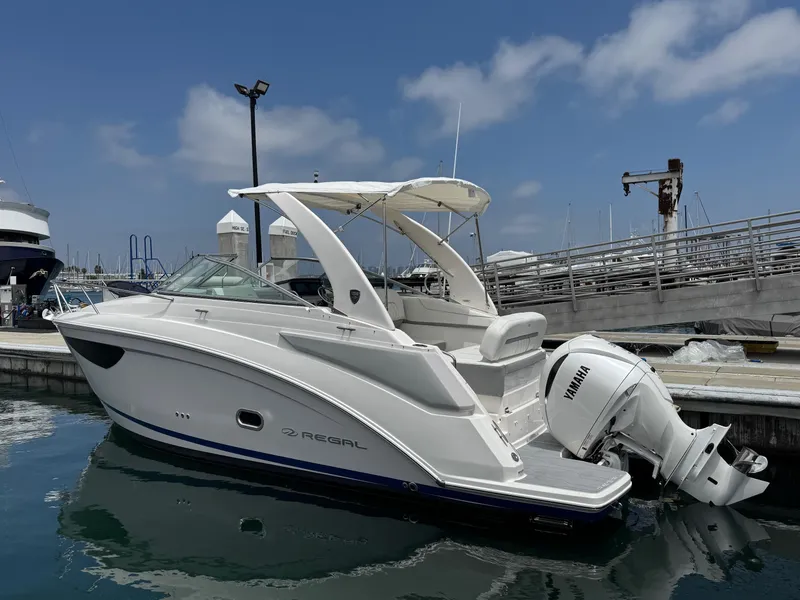 Slide: The Image of 2025 Regal 26 XO boat docked in marina, featuring sleek design and Yamaha outboard motor. - 3
