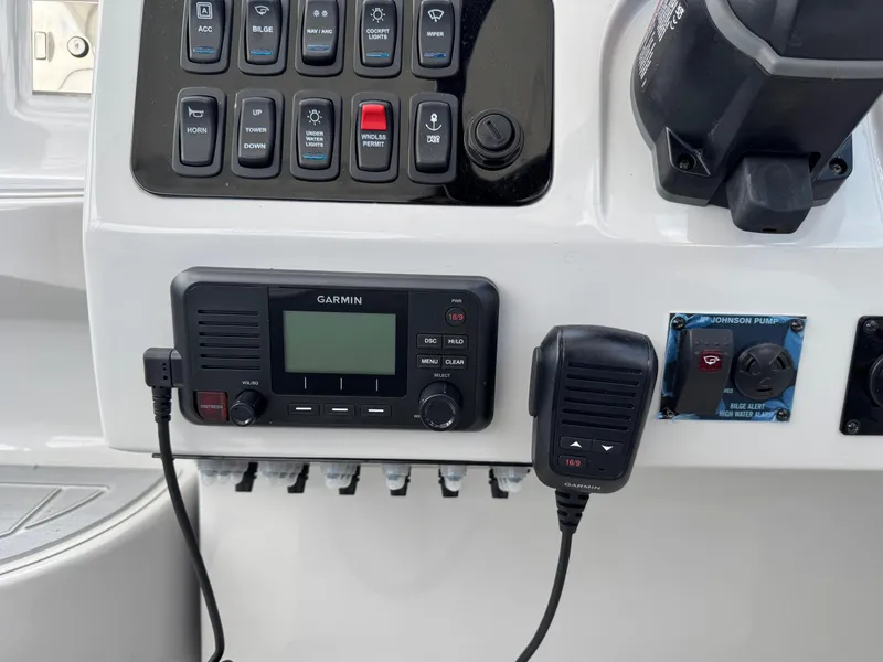 Slide: The Image of Control panel of a 2025 Regal 26 XO boat with Garmin radio and switches. - 32