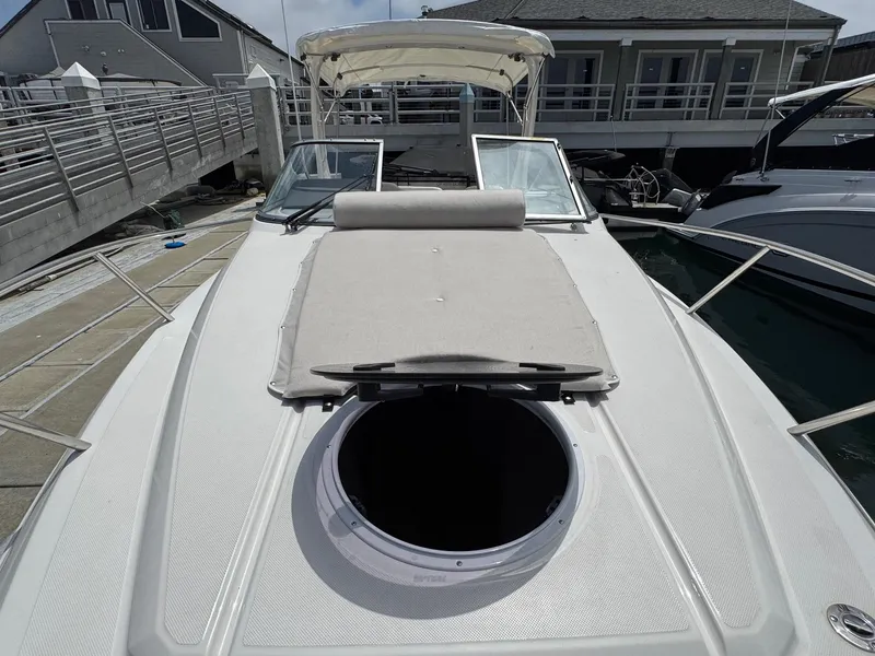 Slide: The Image of 2025 Regal 26 XO boat with sunpad and open hatch, docked at marina. - 36