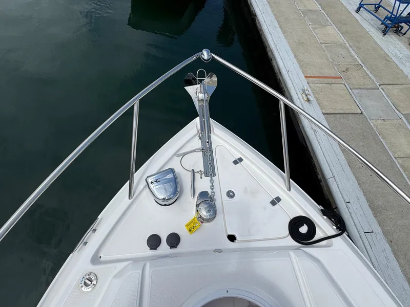 Slide: The Image of Bow of 2025 Regal 26 XO boat docked, featuring anchor and stainless steel railings. - 37