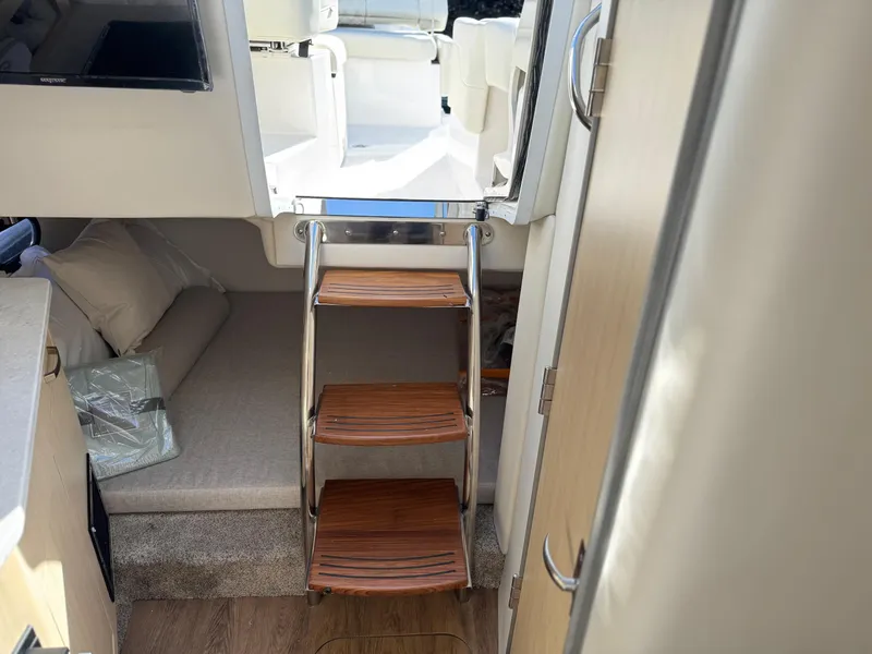 Slide: The Image of Interior of 2025 Regal 26 XO boat with wooden steps and cozy cabin area. - 38