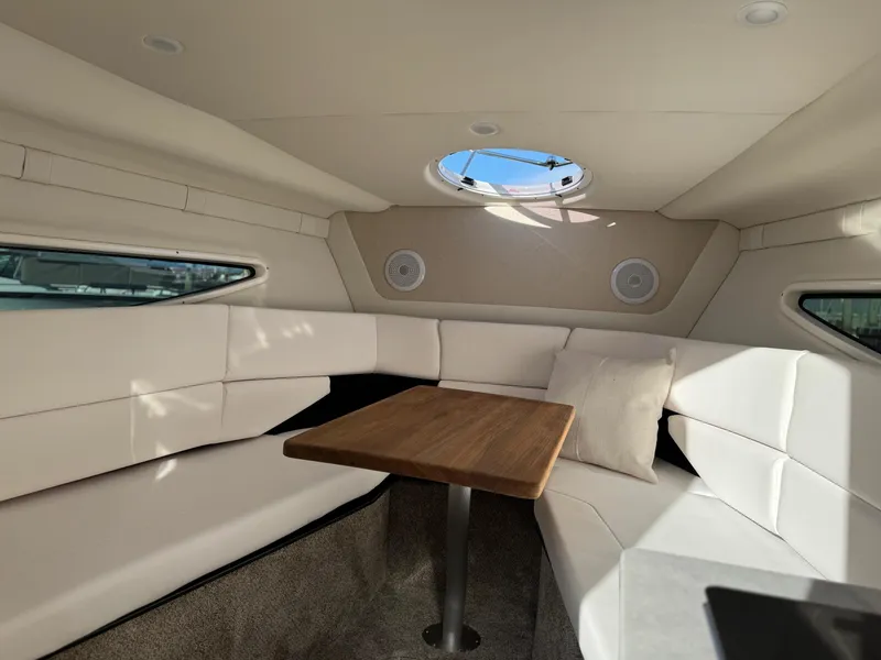 Slide: The Image of 2025 Regal 26 XO cabin interior with plush seating and wooden table. - 42