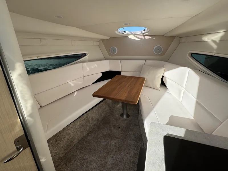 Slide: The Image of 2025 Regal 26 XO cabin interior with plush seating and wooden table. - 43