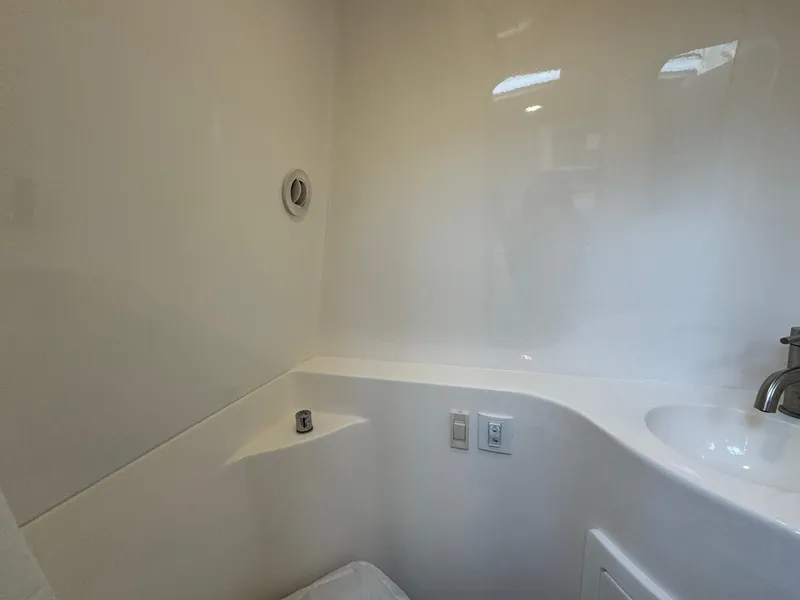 Slide: The Image of 2025 Regal 26 XO boat interior bathroom with sleek white design and modern fixtures. - 47