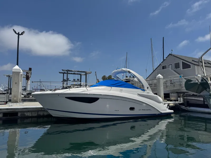 Slide: The Image of 2025 Regal 26 XO boat docked at a marina under a clear blue sky. - 61