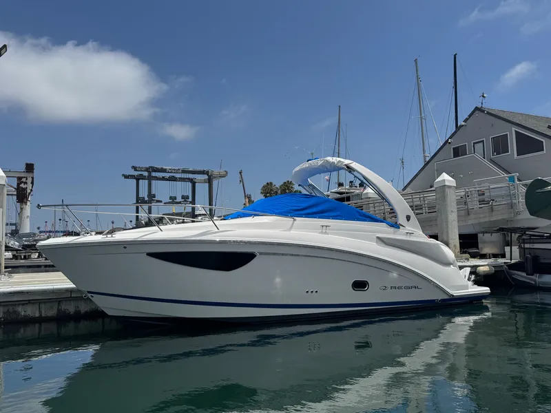 Slide: The Image of 2025 Regal 26 XO boat docked at marina under clear blue sky. - 62
