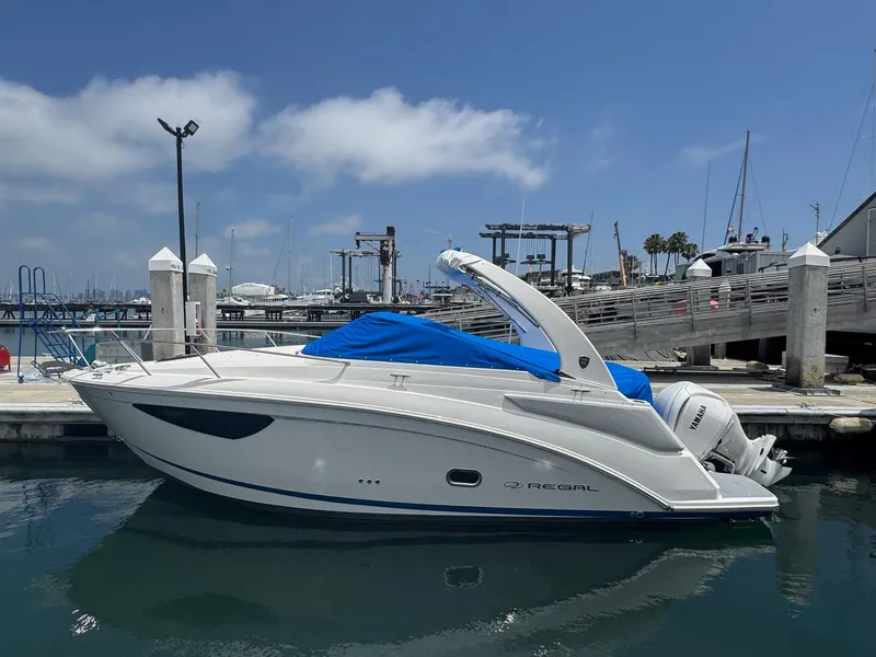 Slide: The Image of 2025 Regal 26 XO boat docked at marina under clear blue sky. - 64