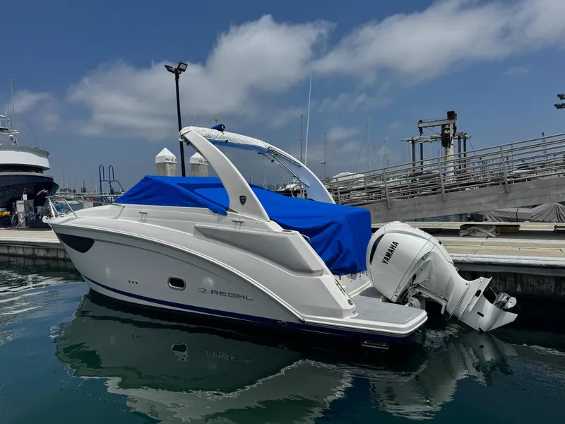 Slide: The Image of 2025 Regal 26 XO boat docked with blue cover and Yamaha outboard motor. - 65