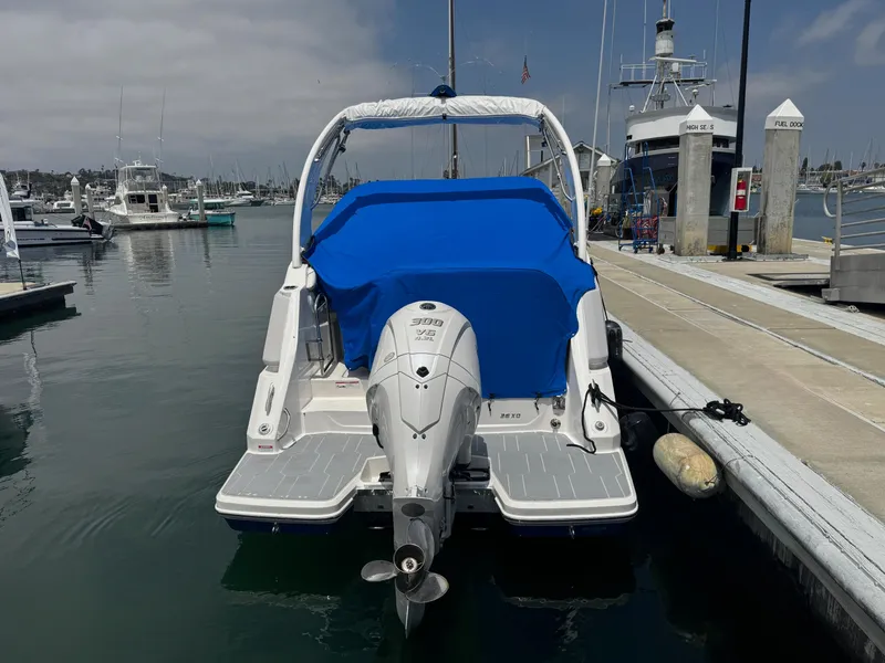 Slide: The Image of 2025 Regal 26 XO boat docked, covered with blue tarp, in a marina setting. - 66