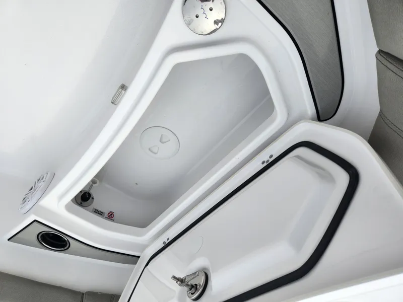 Slide: The Image of 2025 Sportsman Masters 247OE Bay Boat storage compartment, open with visible latch and seal. - 12
