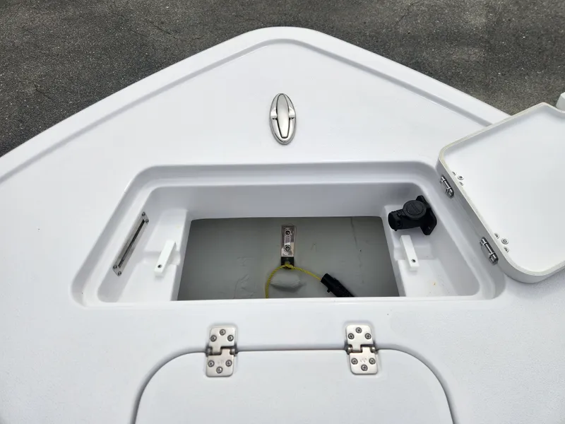 Slide: The Image of 2025 Sportsman Masters 247OE Bay Boat storage compartment with open hatch and visible fittings. - 14