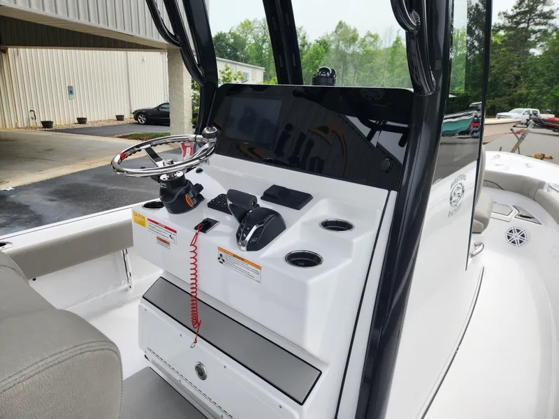 Slide: The Image of 2025 Sportsman Masters 247OE Bay Boat console with steering wheel and controls. - 16
