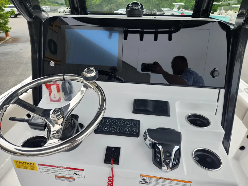 Slide: The Image of 2025 Sportsman Masters 247OE Bay Boat dashboard with steering wheel and control panel. - 17