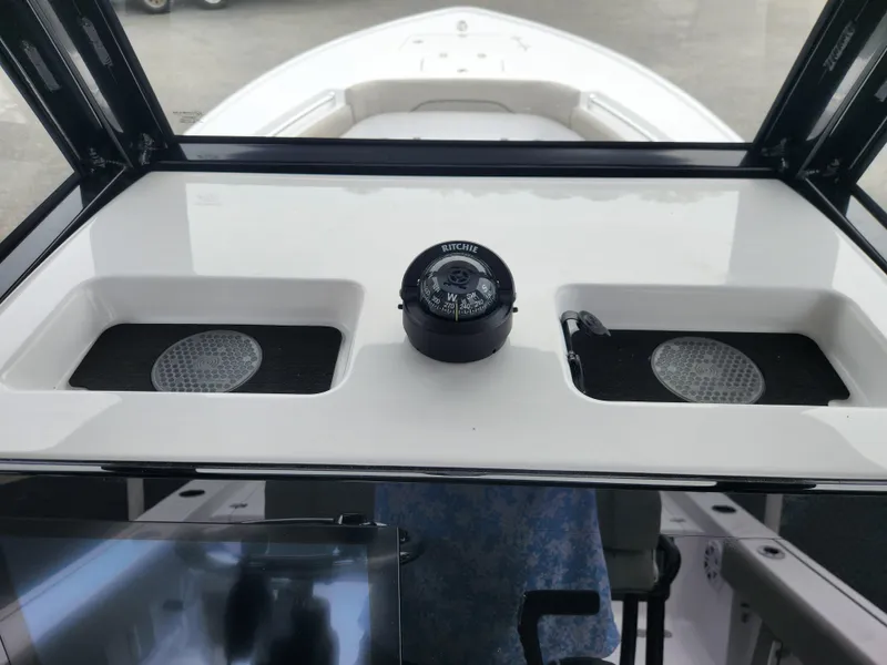 Slide: The Image of 2025 Sportsman Masters 247OE Bay Boat dashboard with compass and storage compartments. - 18