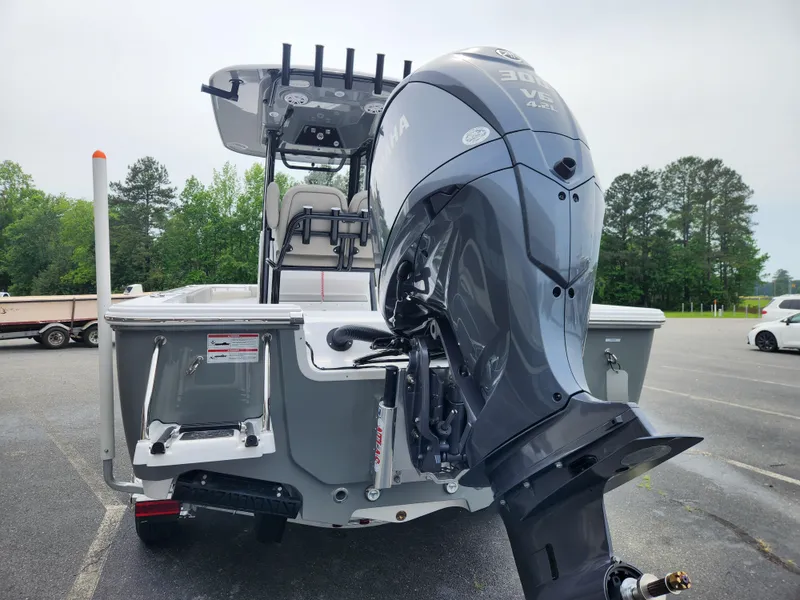 Slide: The Image of 2025 Sportsman Masters 247OE Bay Boat with powerful outboard motor in a parking lot. - 4