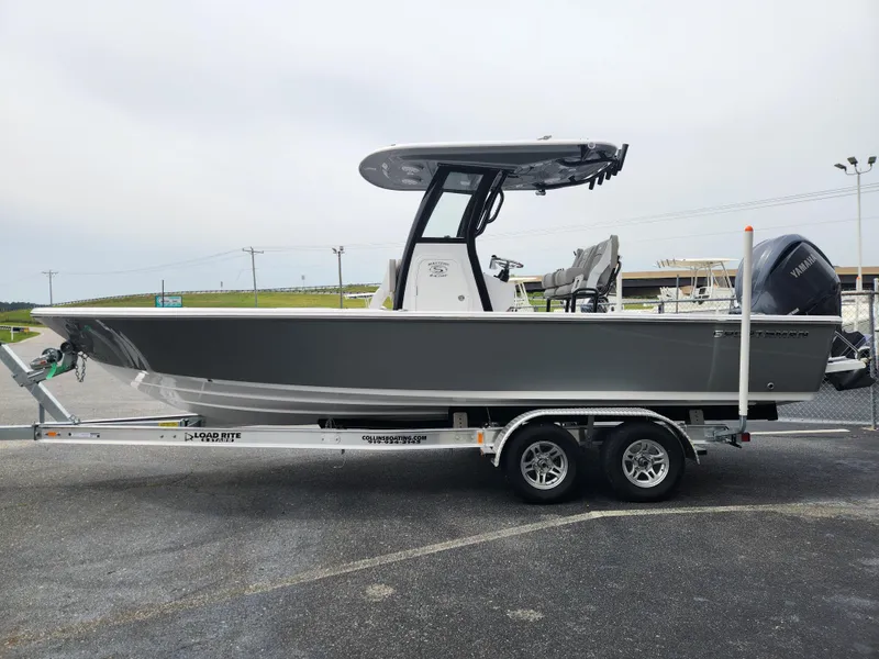 Slide: The Image of 2025 Sportsman Masters 247OE Bay Boat on trailer, side view, gray hull, outdoor setting. - 6