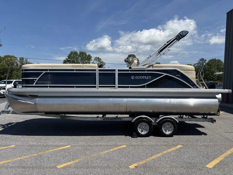 Slide: The Image of 2025 Godfrey SWEETWATER 2286 SB pontoon boat on trailer, parked outdoors. - 16
