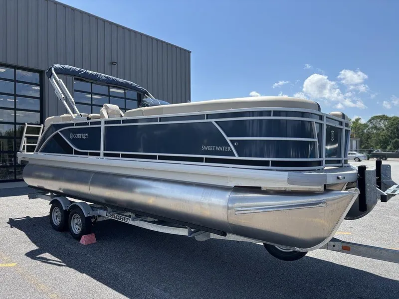 Slide: The Image of 2025 Godfrey SWEETWATER 2286 SB pontoon boat on trailer, parked outdoors. - 20