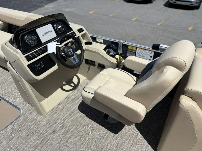 Slide: The Image of 2025 Godfrey SWEETWATER 2286 SB boat interior with Garmin navigation system and beige seating. - 8