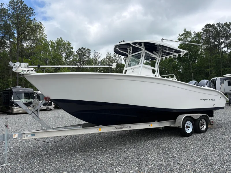 Slide: The Image of 2015 Cape Horn 27X3 boat on trailer, parked outdoors with trees in background. - 1